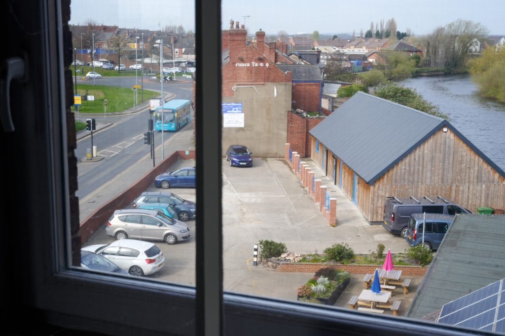 The new boathouse building viewed from above - a double storey wooden cladded building next to the river